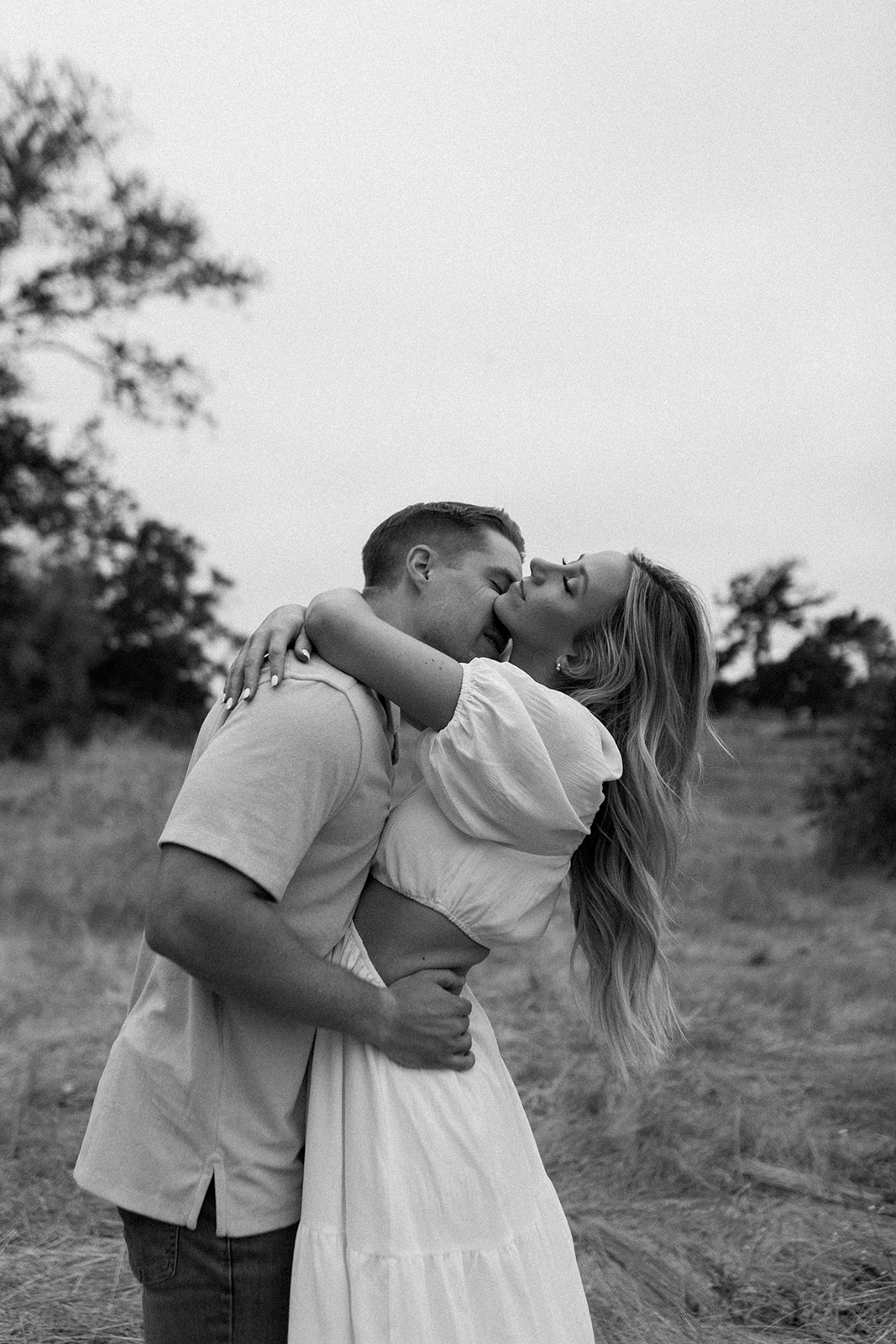 engagement photos in monterey, california, girl with blonde hair and white dress, boy with blonde hair and collared shirt kissing