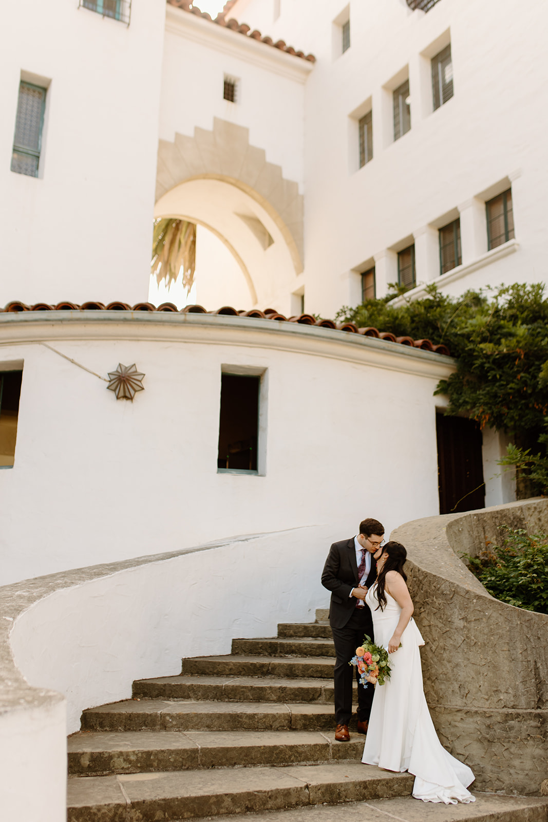 Santa Barbara courthouse elopement with bride and groom posing on the staircase at the courthouse in santa barbara