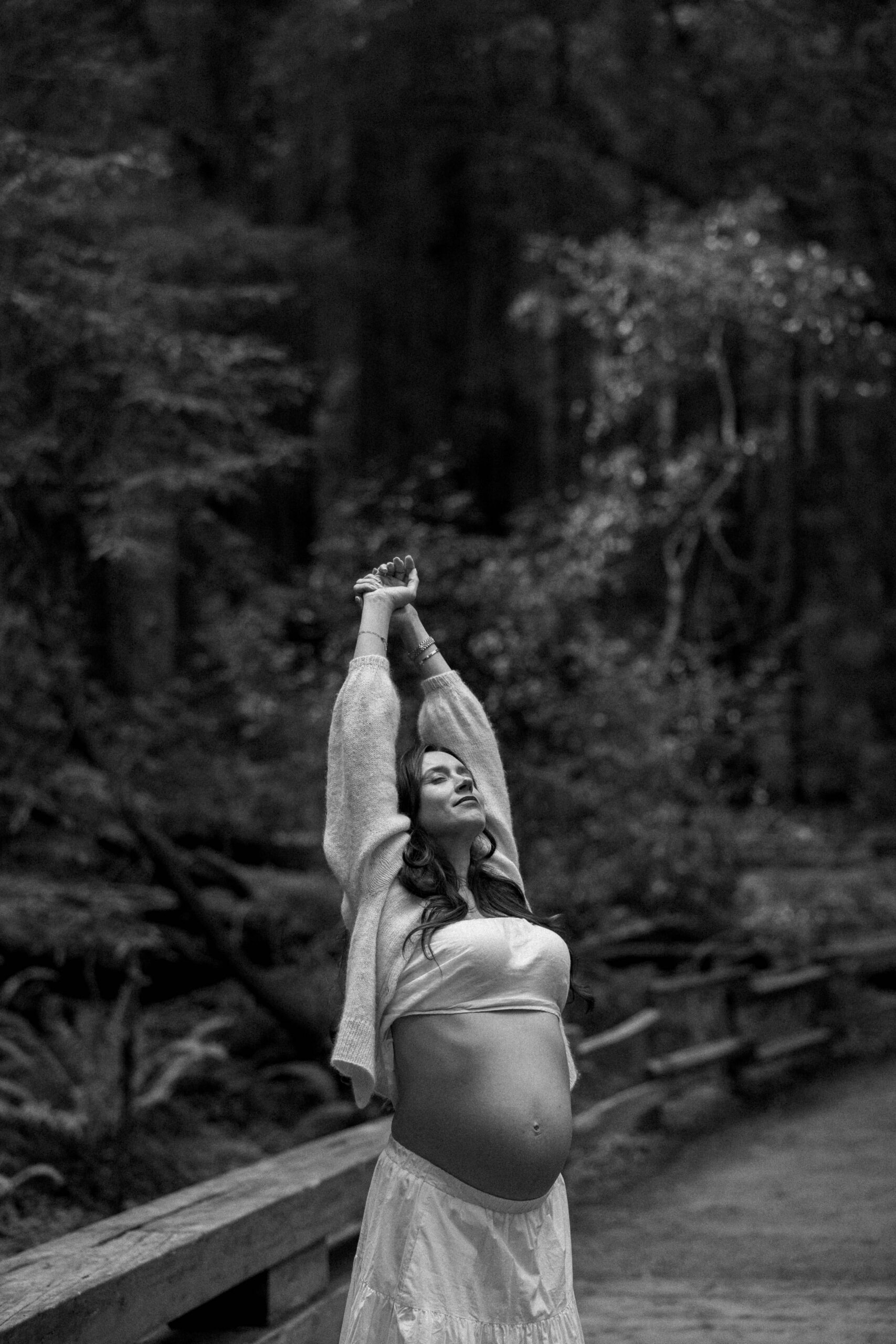 maternity photoshoot in muir woods, pregnant woman reaching for the sky